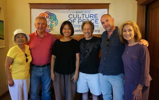 Ashland Culture of Peace members stand with Hideko in front of their banner